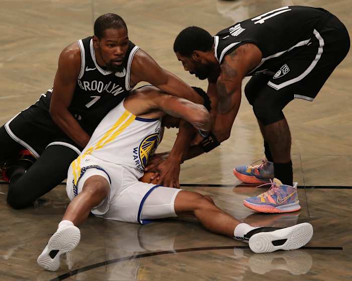 Golden State Warriors shooting guard Kent Bazemore fights for a loose ball against Brooklyn Nets small forward Kevin Durant and point guard Kyrie Irving during the first quarter at Barclays Center.