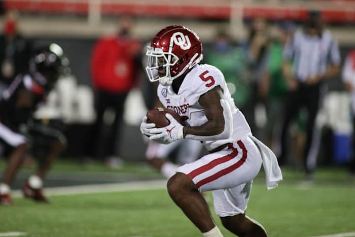 Oct 31, 2020; Lubbock, Texas, USA; Oklahoma Sooners running back TJ Pledger (5) rushes against the Texas Tech Red Raiders in the first half at Jones AT&T Stadium.
