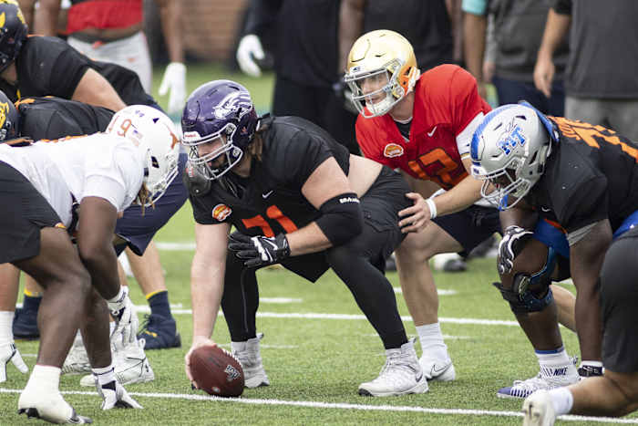 National offensive lineman Quinn Meinerz of Wisconsin -Whitewater (71) gets set with National quarterback Ian Book of Notre Dame (12) in drills during National team practice during the 2021 Senior Bowl week.