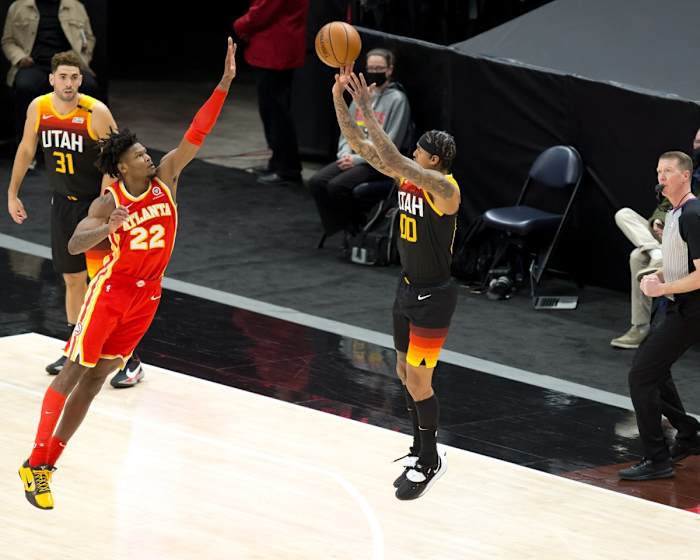Jordan Clarkson (00) shoots a three-pointer over Cam Reddish (22) 