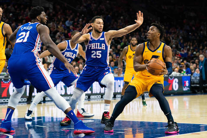 Donovan Mitchell (45) looks to shoot over Ben Simmons (25) and Joel Embiid (21)