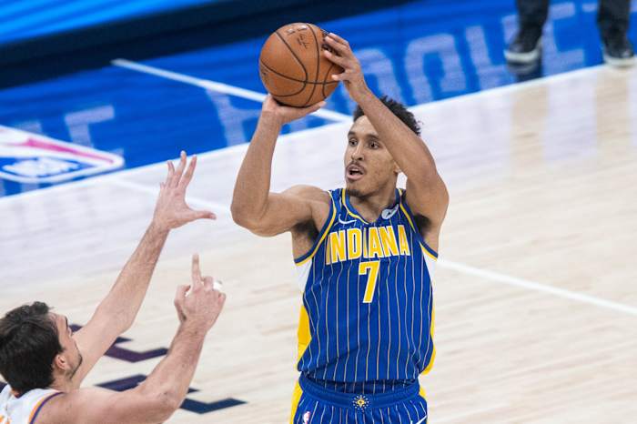 Jan 9, 2021; Indianapolis, Indiana, USA; Indiana Pacers guard Malcolm Brogdon (7) shoots the ball over Phoenix Suns forward Dario Saric (left) in the third quarter at Bankers Life Fieldhouse. Mandatory Credit: Trevor Ruszkowski-USA TODAY Sports