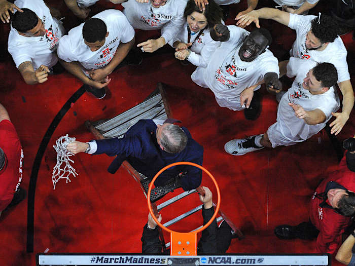 San Diego State head coach Brian Dutcher holds the net after defeating New Mexico and clinching a share of the Mountain West regular season title at Viejas Arena.