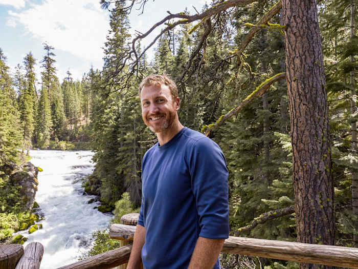 Mariners mental skills coach Adam Bernero stands in front of a rushing river.