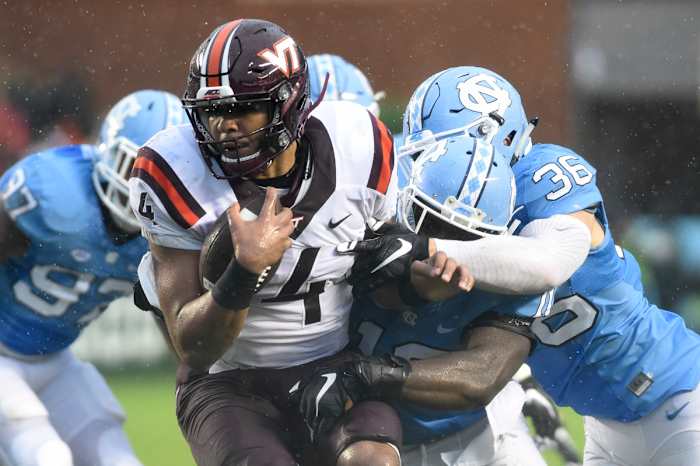 Oct 8, 2016; Chapel Hill, NC, USA; Virginia Tech Hokies quarterback Jerod Evans (4) is tackled by North Carolina Tar Heels linebackers Andre Smith (10) and Cole Holcomb (36) in the first half at Kenan Memorial Stadium. Mandatory Credit: Bob Donnan-USA TODAY Sports