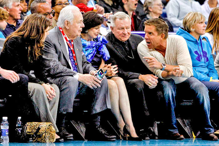 Tom Benson (above, left), the late Saints and Pelicans owner, willed the teams to Gayle; the archbishop regularly joined them at games.