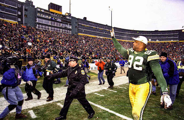 Packers legend Reggie White waves to the crowd as he leaves Lambeau Field