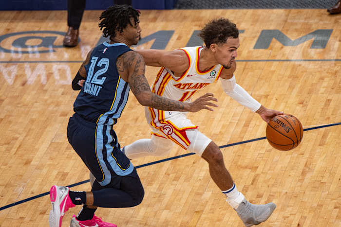 Atlanta Hawks guard Trae Young dribbles past Memphis Grizzlies guard Ja Morant.