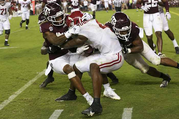 Oct 9, 2021; College Station, Texas, USA; Alabama Crimson Tide running back Brian Robinson Jr. (4) is tackled Texas A&M Aggies defensive back Tyreek Chappell (7) and linebacker Aaron Hansford (1) in the second half at Kyle Field. Mandatory Credit: Thomas Shea-USA TODAY Sports