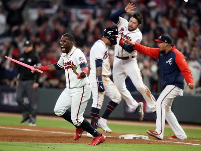 Oct 17, 2021; Cumberland, Georgia, USA; Atlanta Braves center fielder Guillermo Heredia (38) celebrates with toy swords as left fielder Eddie Rosario (8) celebrates his walk off game winning RBI against the Los Angeles Dodgers during the ninth inning in game two of the 2021 NLCS at Truist Park.