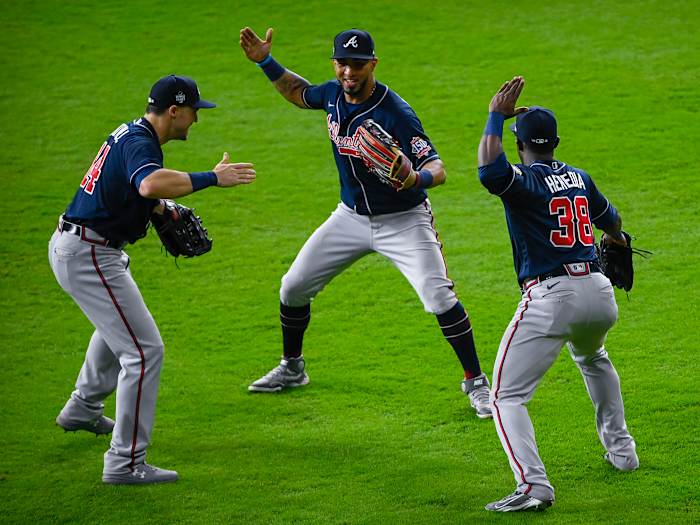 Atlanta Braves center fielder Adam Duvall (14) and left fielder Eddie Rosario (8) and center fielder Guillermo Heredia (38) celebrate the win over the Houston Astros in game one of the 2021 World Series.