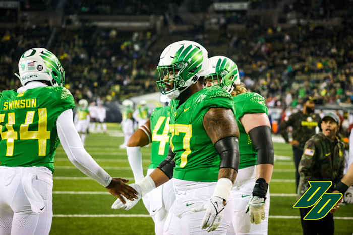 Moore high fives teammate Bradyn Swinson as the Ducks go through pre game warmups vs. Washington State.
