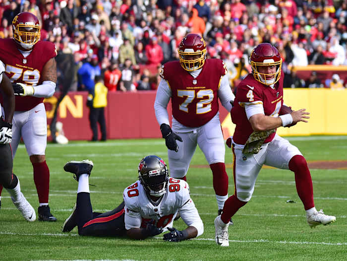 Washington Football Team quarterback Taylor Heinicke runs away from Tampa Bay Buccaneers defensive lineman Jason Pierre-Paul