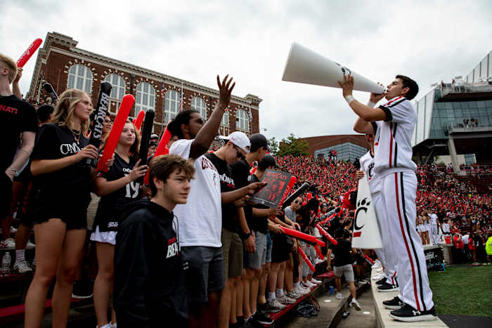 Cincinnati Bearcats cheerleader leads the student section in cheers before the NCAA football game between the Cincinnati Bearcats and the Miami Redhawks on Saturday, Sept. 4, 2021, at Nippert Stadium in Cincinnati. Cincinnati Bearcats Miami Redhawks