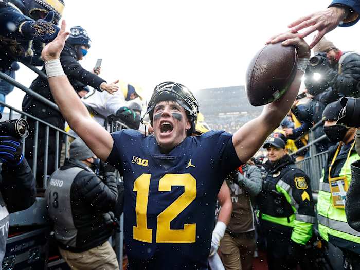 Michigan QB Cade McNamara celebrates the win over Ohio State with fans