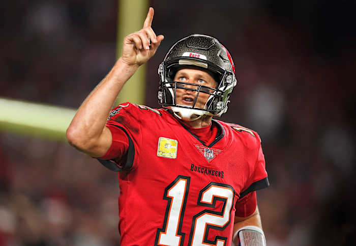Tom Brady points to the sky as he runs on the field for a Bucs game