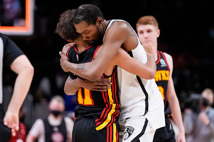Hawks guard Trae Young hugs Nets forward Kevin Durant.