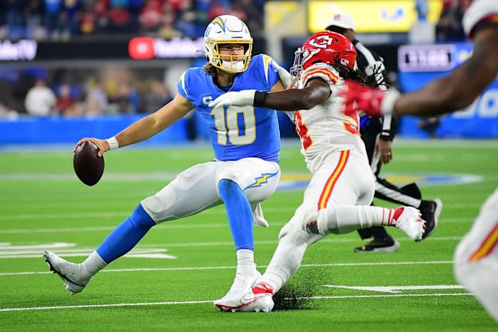 Dec 16, 2021; Inglewood, California, USA; Los Angeles Chargers quarterback Justin Herbert (10) moves the ball under pressure from Kansas City Chiefs outside linebacker Nick Bolton (54) during the second half at SoFi Stadium. Mandatory Credit: Gary A. Vasquez-USA TODAY Sports