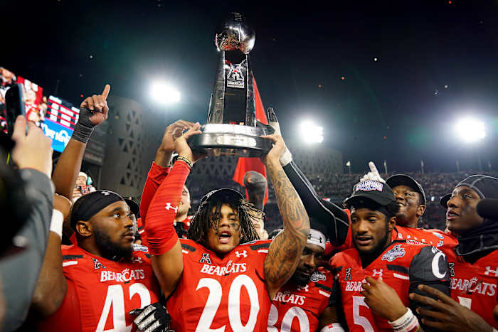 Cincinnati Bearcats linebacker Deshawn Pace (20) raises the trophy of the American Athletic Conference championship football game, Saturday, Dec. 4, 2021, at Nippert Stadium in Cincinnati. The Cincinnati Bearcats defeated the Houston Cougars, 35-20. Houston Cougars At Cincinnati Bearcats Aac Championship Dec 4