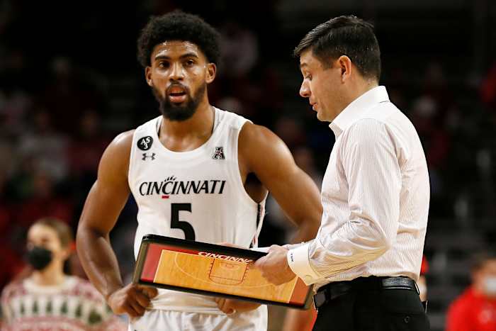 Cincinnati Bearcats head coach Wes Miller talks with guard David DeJulius (5) during a timeout in the second half of the NCAA basketball game between the Cincinnati Bearcats and the Tennessee Tech Golden Eagles at Fifth Third Arena in Cincinnati on Tuesday, Dec. 21, 2021. Cincinnati finished its non-conference schedule with a 76-67 win over the Golden Eagles. Tennessee Tech Golden Eagles At Cincinnati Bearcats Basketball