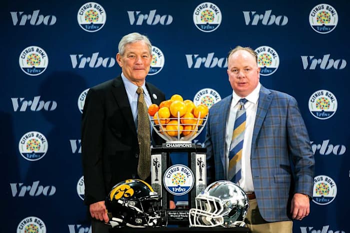 Iowa head coach Kirk Ferentz, left, and Kentucky head coach Mark Stoops pose for a photo with the trophy during a news conference for the Vrbo Citrus Bowl, Friday, Dec. 31, 2021, at the Rosen Plaza Hotel in Orlando, Fla. 211231 Citrus Iowa Kentucky Presser 012 Jpg