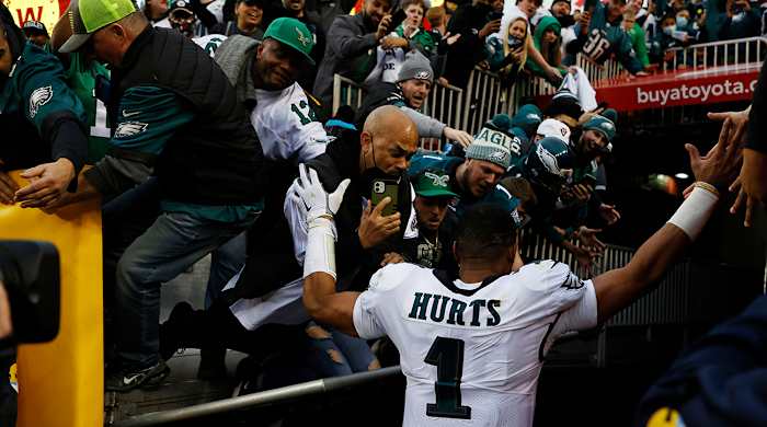 Jalen Hurts exits when a railing collapses and fans fall on the field.