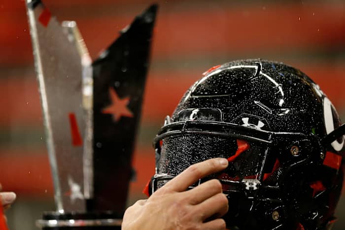 Cincinnati Bearcats quarterback Desmond Ridder (9) picks up his helmet and MVP trophy as he heads for the locker room after the fourth quarter of the NCAA American Athletic Conference Championship game between the Cincinnati Bearcats and the Tulsa Golden Hurricane at Nippert Stadium in Cincinnati on Saturday, Dec. 19, 2020. The Bearcats continued an unbeaten streak at home on their way to securing the AAC Championship title with a 27-24 win. Tulsa Golden Hurricane At Cincinnati Bearcats Aac Championship