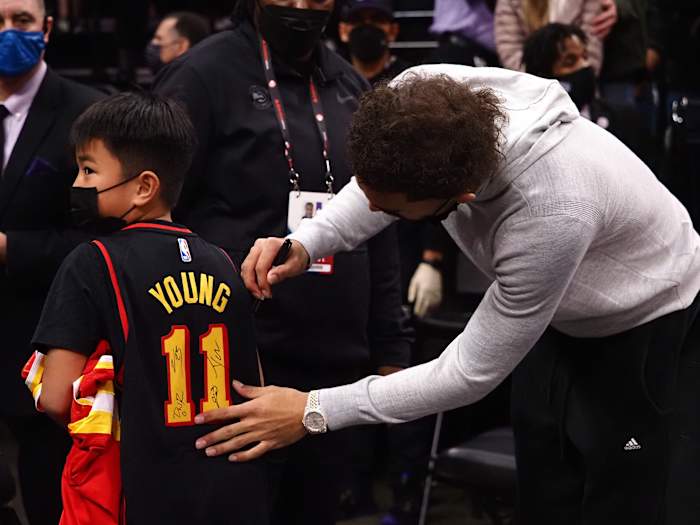 Jan 5, 2022; Sacramento, California, USA; Atlanta Hawks guard Trae Young (11) signs the jersey of a young fan after the game against the Sacramento Kings at Golden 1 Center.