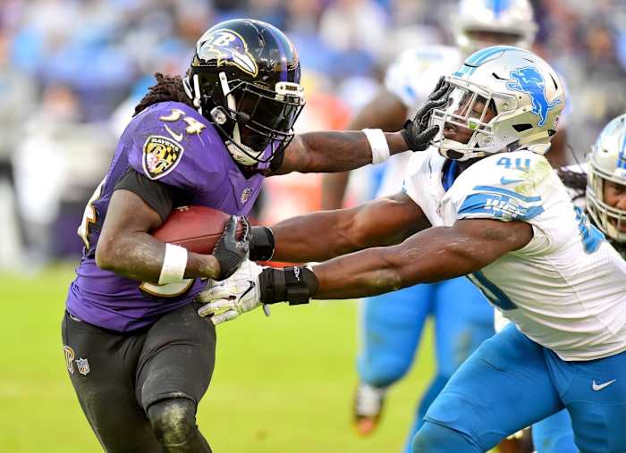 Baltimore Ravens running back Alex Collins (34) stiff arms Detroit Lions linebacker Jarrad Davis (40) in the fourth quarter at M&T Bank Stadium.
