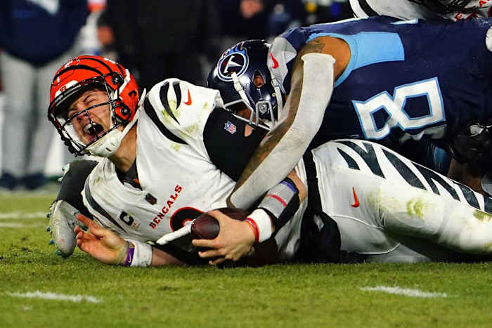 Cincinnati Bengals quarterback Joe Burrow (9) is sacked in the fourth quarter during an NFL divisional playoff football game against the Tennessee Titans, Saturday at Nissan Stadium in Nashville. The Cincinnati Bengals defeated the Tennessee Titans, 19-16, to advance to the AFC Championship game.