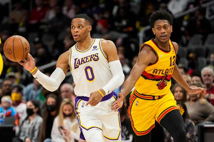 Jan 30, 2022; Atlanta, Georgia, USA; Los Angeles Lakers guard Russell Westbrook (0) passes the ball defended by Atlanta Hawks forward De'Andre Hunter (12) during the first quarter at State Farm Arena.