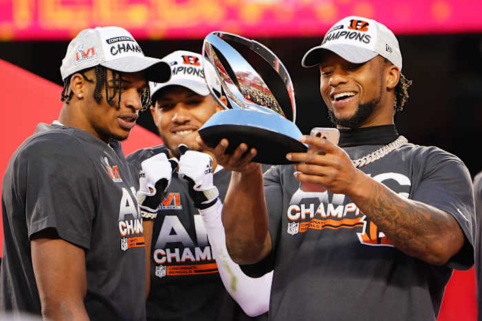 Cincinnati Bengals wide receiver Ja'Marr Chase (1), Cincinnati Bengals wide receiver Tyler Boyd (83) and Cincinnati Bengals running back Joe Mixon (28) admire the AFC Championship trophy at the conclusion of the AFC championship NFL football game, Sunday, Jan. 30, 2022, at GEHA Field at Arrowhead Stadium in Kansas City, Mo. The Cincinnati Bengals defeated the Kansas City Chiefs, 27-24, to advance to the Super Bowl. Cincinnati Bengals At Kansas City Chiefs Jan 30 Afc Championship 1556