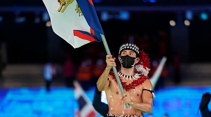 Nathan Crumpton, of American Samoa, carries his national flag into the stadium during the opening ceremony of the 2022 Winter Olympics, Friday, Feb. 4, 2022, in Beijing.