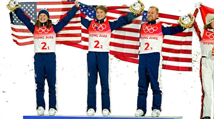Ashley Caldwell, Christopher Lillis and Justin Schoenefeld celebrate winning the gold medal in the Mixed Freestyle Skiing Aerials Team Final during the Beijing 2022 Olympic Winter Games.