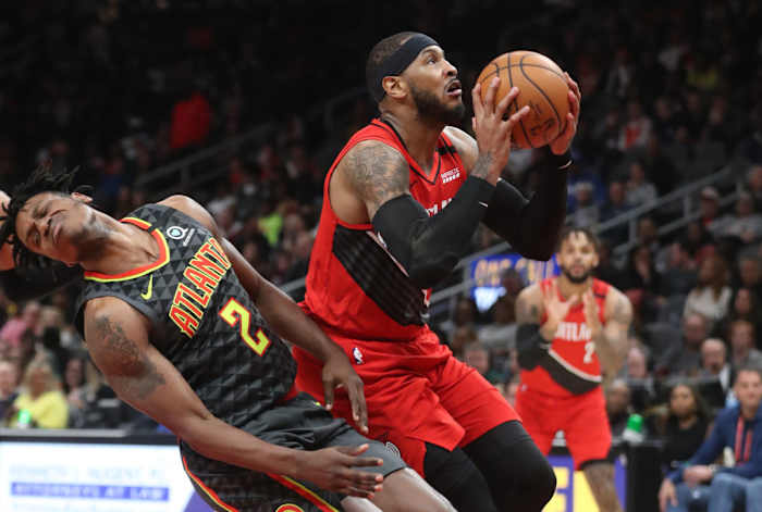 Feb 29, 2020; Atlanta, Georgia, USA; Portland Trail Blazers forward Carmelo Anthony (00) fouls Atlanta Hawks guard Treveon Graham (2) as Anthony attempts a shot in the second quarter at State Farm Arena.