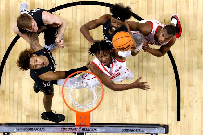 Houston Cougars center Josh Carlton (25) rises to the basket as Cincinnati Bearcats guard Jeremiah Davenport (24), left, and Cincinnati Bearcats forward John Newman III (15), center, defend in the second half of an NCAA men s college basketball game, Sunday, Feb. 6, 2022, at Fifth Third Arena in Cincinnati. The Houston Cougars defeated the Cincinnati Bearcats, 80-58. Houston Cougars At Cincinnati Bearcats Feb 7
