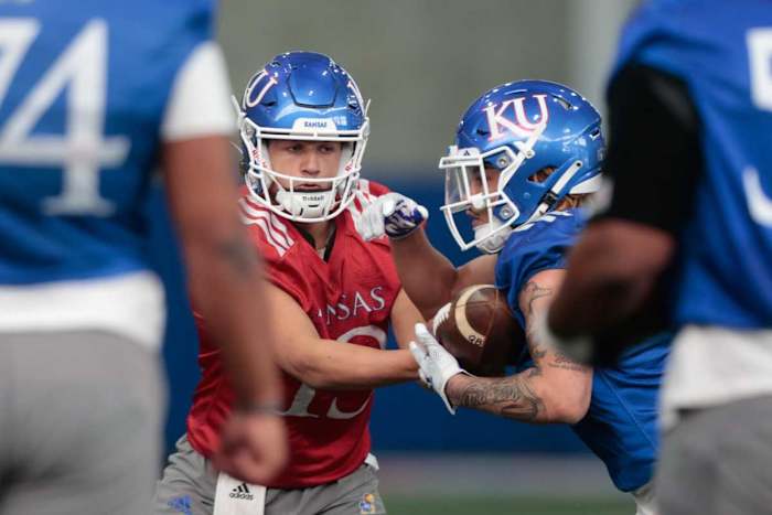 Kansas redshirt junior quarterback Jordan Preston (13) passes to redshirt sophomore running back Ky Thomas (8) during practice Tuesday morning in Lawrence.