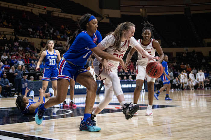 Mar 11, 2022; Kansas City, MO, USA; Oklahoma Sooners guard Taylor Robertson (30) dribbles while defended by Kansas Jayhawks center Taiyanna Jackson (1) in the second half at Municipal Auditorium. Mandatory Credit: Amy Kontras-USA TODAY Sports