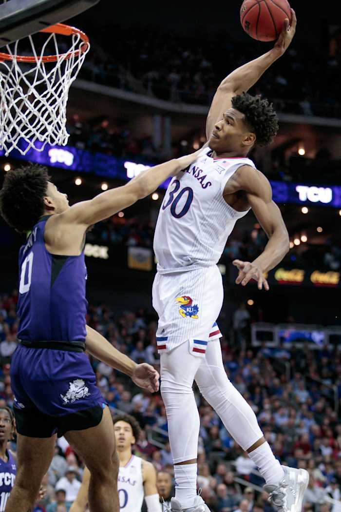 Mar 11, 2022; Kansas City, MO, USA; Kansas Jayhawks guard Ochai Agbaji (30) goes up to dunk over TCU Horned Frogs guard Micah Peavy (0) during the second half at T-Mobile Center. Mandatory Credit: William Purnell-USA TODAY Sports