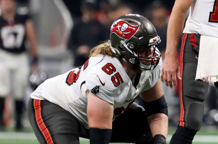Dec 5, 2021; Atlanta, Georgia, USA; Tampa Bay Buccaneers quarterback Tom Brady (12) makes a pre-snap call as guard Alex Cappa (65) and center Ryan Jensen (66) are shown during the second half against the Atlanta Falcons at Mercedes-Benz Stadium. Mandatory Credit: Jason Getz-USA TODAY Sports
