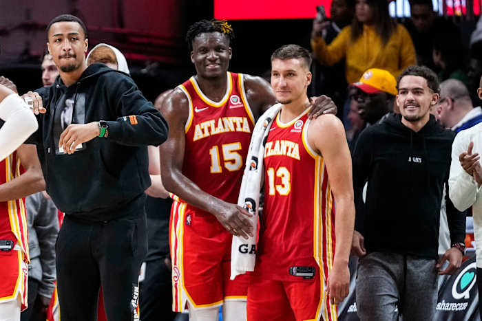 John Collins, Clint Capela, Bogdan Bogdanovic, and Trae Young celebrate on the sideline.