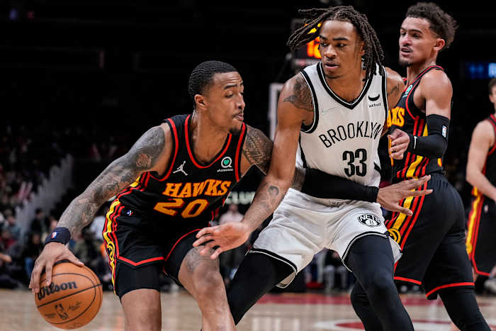 Atlanta Hawks forward John Collins tries to dribble past Brooklyn Nets forward Nic Claxton.