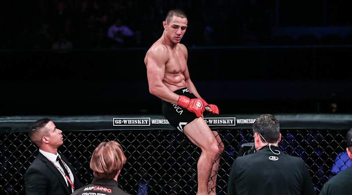 Aaron Pico sits atop the Bellator cage.
