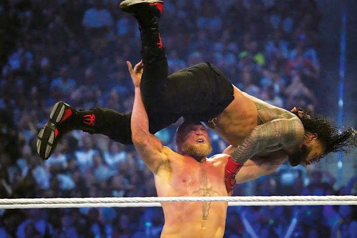 WWE champion Brock Lesnar hits Universal champion Roman Reigns with an F5 during their champion vs. champion match at Wrestlemania 38 in AT&T Stadium in Arlington, Texas.
