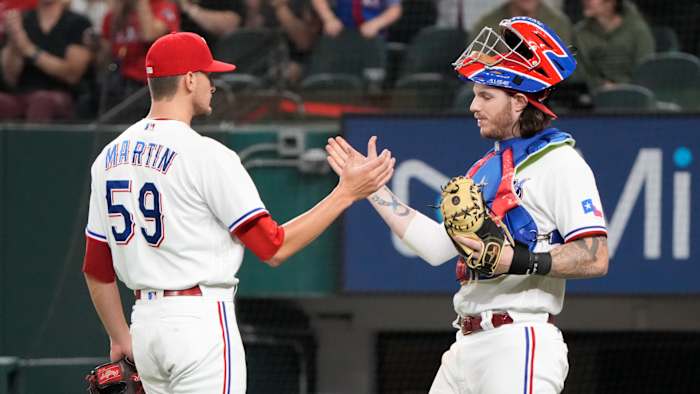Oct 2, 2021; Arlington, Texas, USA; Texas Rangers relief pitcher Brett Martin (59) and catcher Jonah Heim (right) celebrates their teams win over the Cleveland Indians at Globe Life Field. Mandatory Credit: Jim Cowsert-USA TODAY Sports