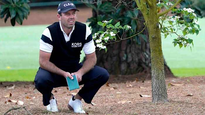 Charl Schwartzel sizes up a shot from the pine straw during the second round of the 2022 Masters.