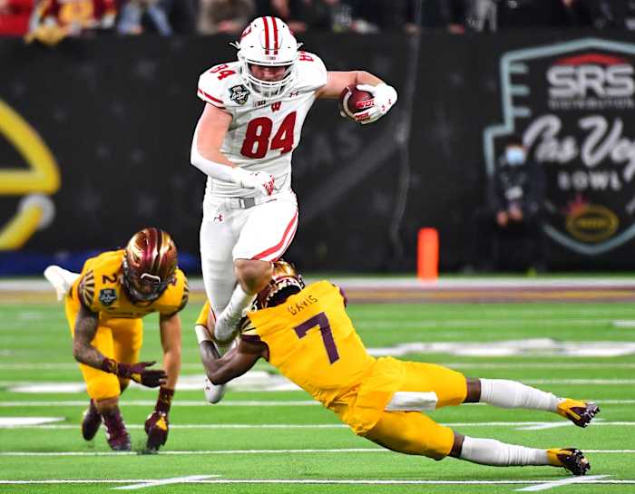 Dec 30, 2021; Paradise, Nevada, USA; Wisconsin Badgers tight end Jake Ferguson (84) attempts to run through the tackle of Arizona State Sun Devils defensive back Timarcus Davis (7) after evading Arizona State Sun Devils defensive back DeAndre Pierce (2) during the 2021 Las Vegas Bowl at Allegiant Stadium.