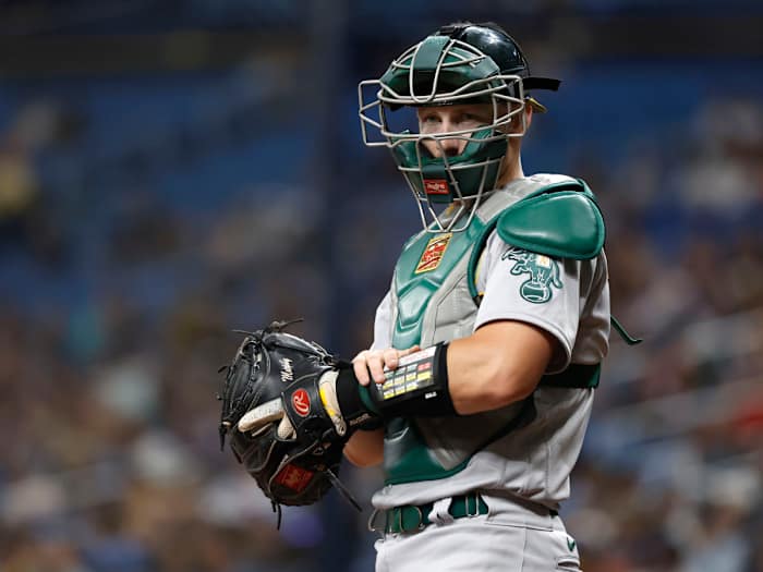 Apr 11, 2022; St. Petersburg, Florida, USA; Oakland Athletics catcher Sean Murphy (12) presses a button on his wristband and it sends a signal to a receiver in the pitcher’s hat, which then speaks to the pitcher and tells them what pitch to throw, during the first inning at Tropicana Field.