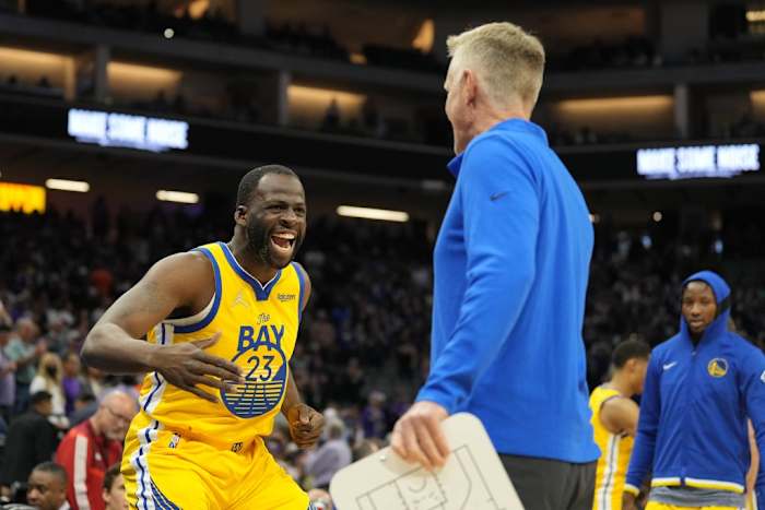 Four-time NBA All-Star Draymond Green slaps hands with Golden State Warriors head coach Steve Kerr.