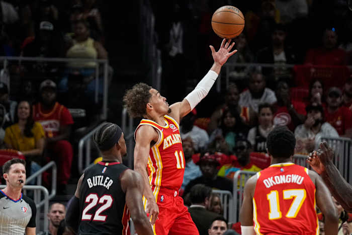 Apr 22, 2022; Atlanta, Georgia, USA; Atlanta Hawks guard Trae Young (11) scores a basket behind Miami Heat forward Jimmy Butler (22) during the first half of game three of the first round for the 2022 NBA playoffs at State Farm Arena.